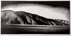 Image of Wood engraving by artist Paul Landacre, entitled "Coachella Valley" and illustrating the mountains bordering the valley with a small train billowing smoke.
